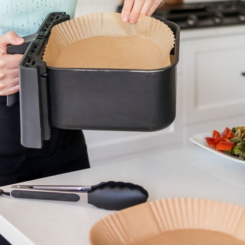 Putting a clean air fryer liner in the air fryer tray