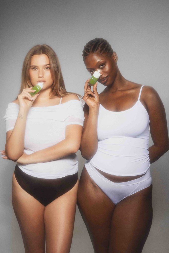 Two female models posing next to each other with eyeam bottles