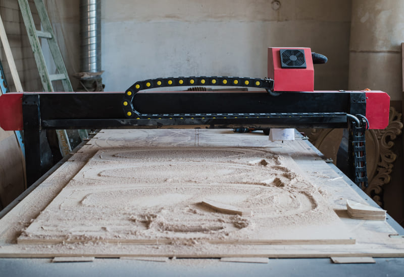 cnc machine cutting wood and creating wood dust