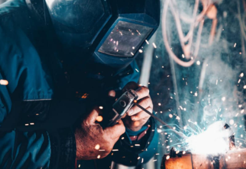 man using a metal welder