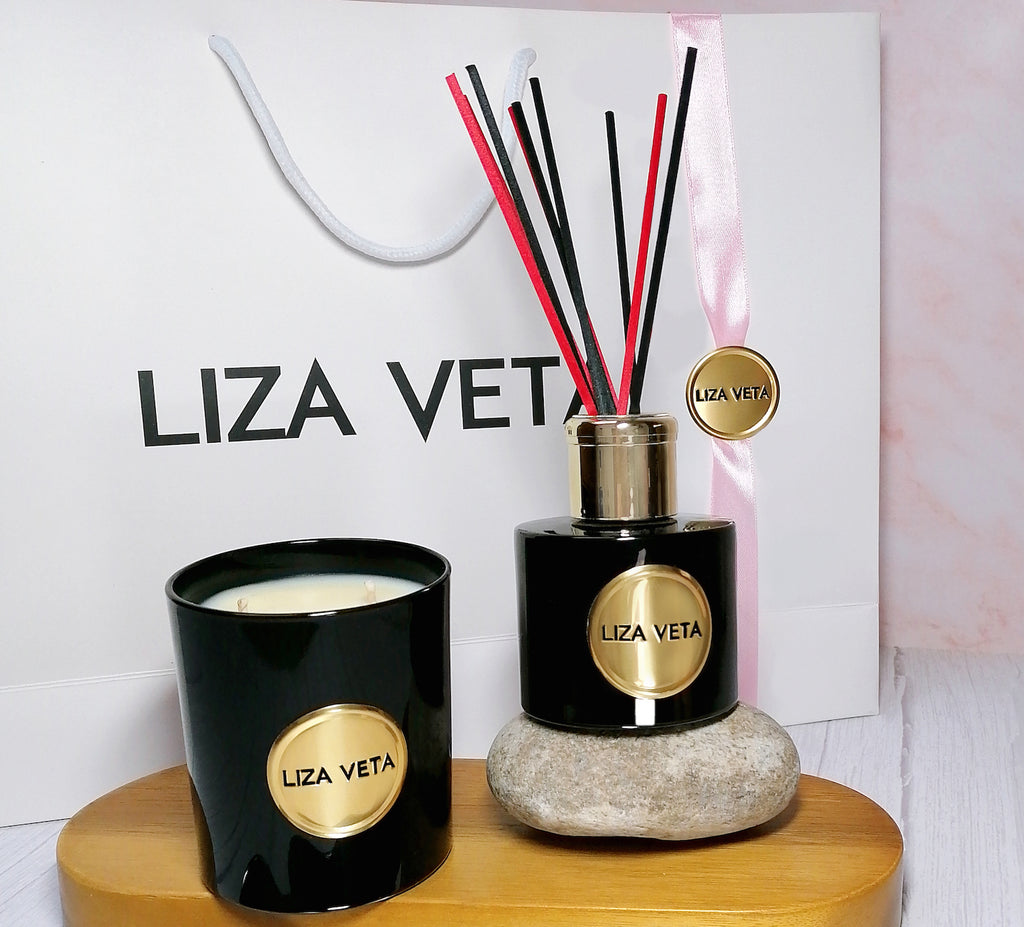 This is a gift set with white branded bag, black glossy small candle and black glossy aromatherapy reed diffuser. This image is related to how to choose a perfect gift.