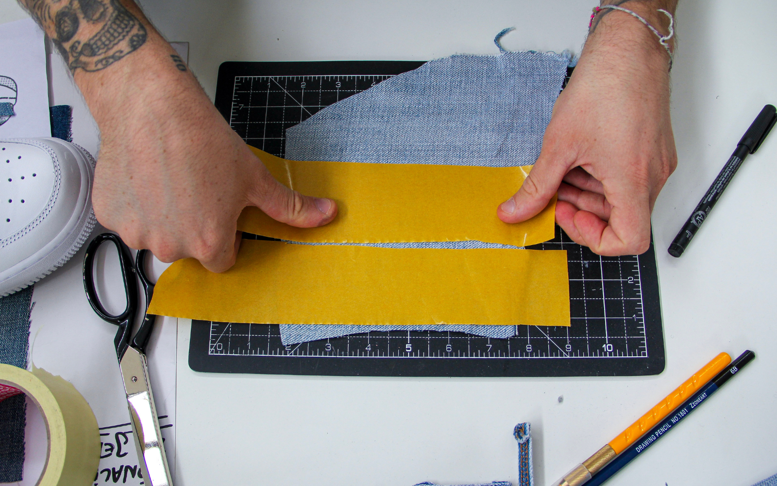 Before cutting the fabric following the paper pattern, cover the bottom part of the jeans entirely with double-sided tape