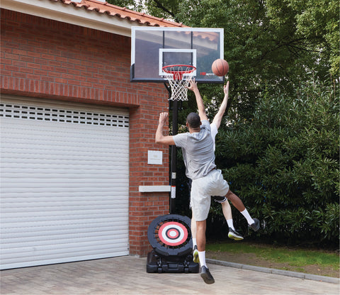 Two men playing basketball on a portable basketball hoop from IE Sports.