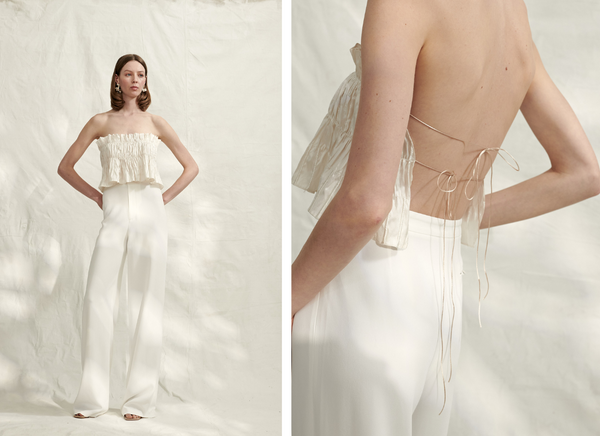 Woman wearing Atelier Blanche strapless ruched silk bustier top with ties at back and white tailored pant