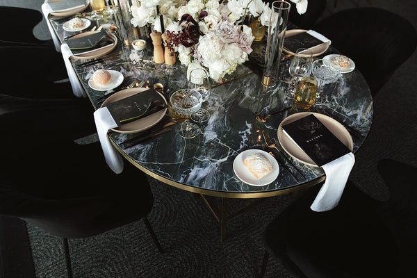 wedding table setting in dark tones with natural plates and candle centrepiece