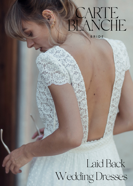 Woman wearing a French lace wedding dress with cap sleeves and open back
