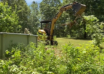 A Cat 303C mini excavator digs out bushes