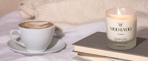 relaxing candle with books and a hot drink