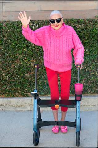 Senior Lady Jane at 95 Still Modeling Camino Smart Walker in Pink Jumper and Red Leggings
