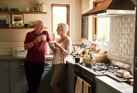Senior couple spending quality time together drinking coffee in their kitchen at home
