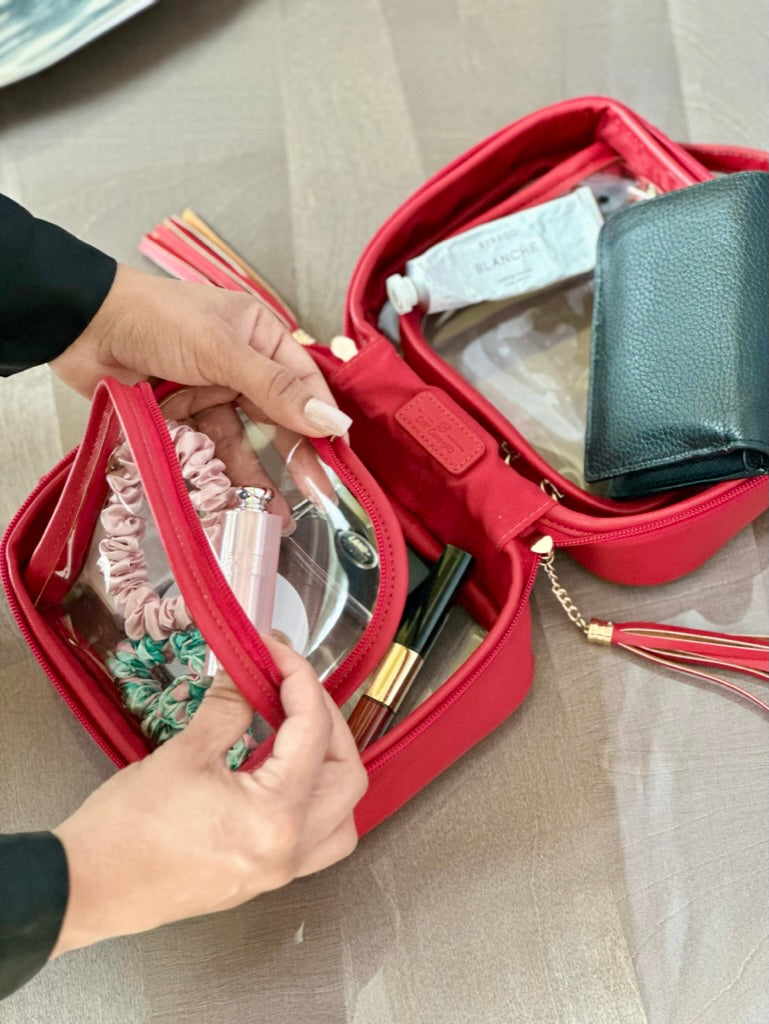 A girl is opening a pocket of a Red Crossbody bag