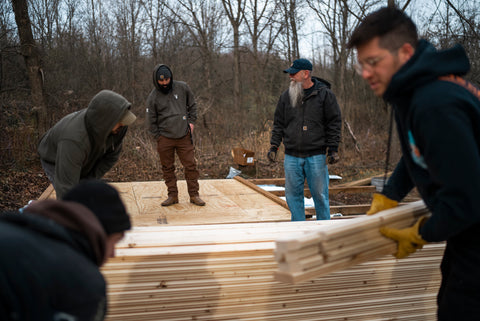 4 men working on building a wooden tiny house