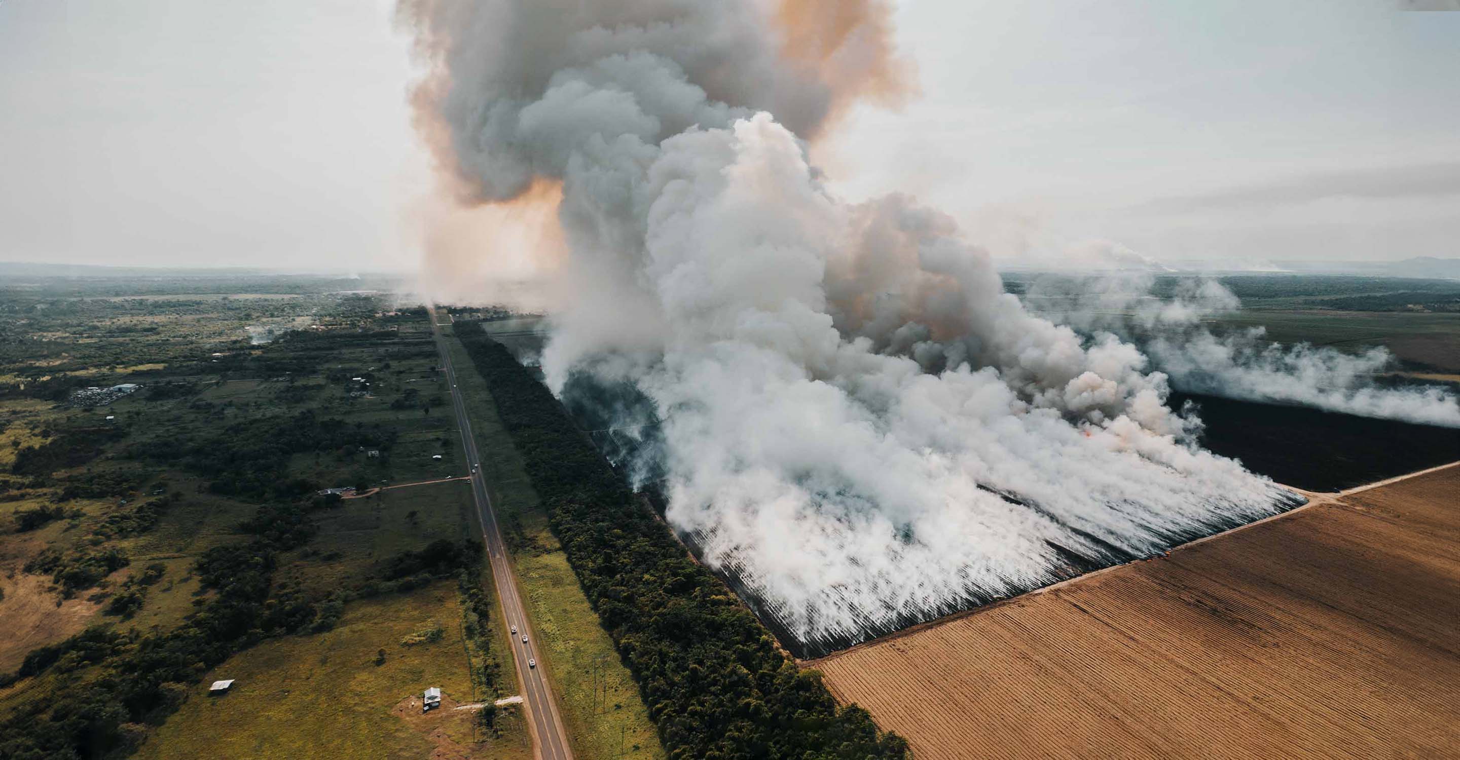 two Pakistani men, one holding AirVisual Pro air quality monitor Crop burning smoke: A global health threat