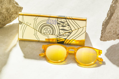 C-3PO sunglasses and triangle case lying on desert sand