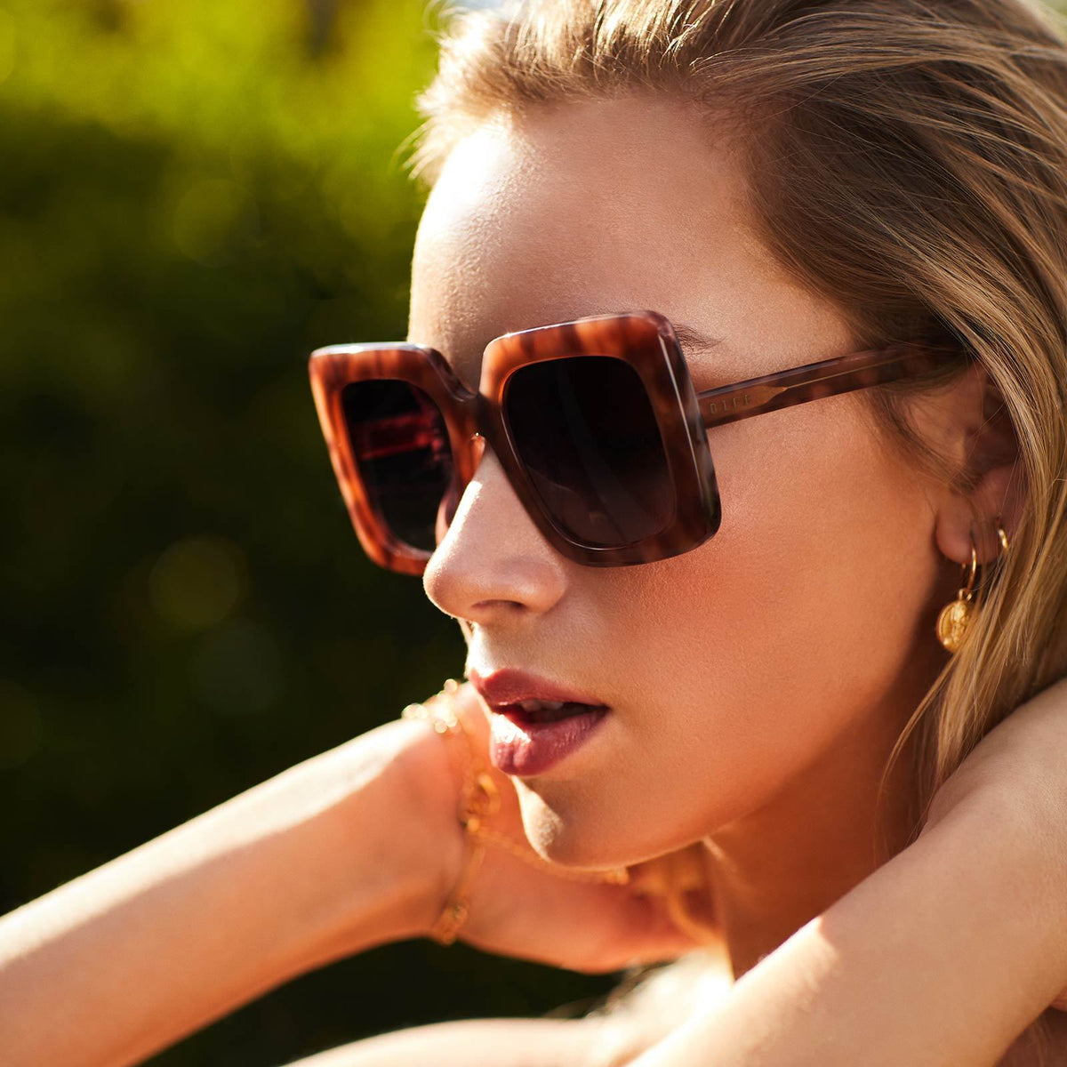 Sunglasses with plum tort frames on a female model