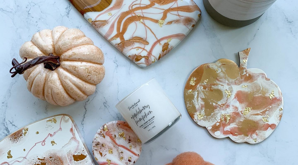 a variety of diy halloween home decor and crafts including an orange pumpkin and resin coasters sitting on top of a marble countertop