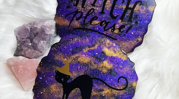 purple halloween resin coasters with a cat and the say "witch please..." on them sitting on top of a white fur surface