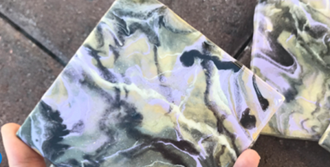 white, gray, and green resin art coasters sitting on a gray background