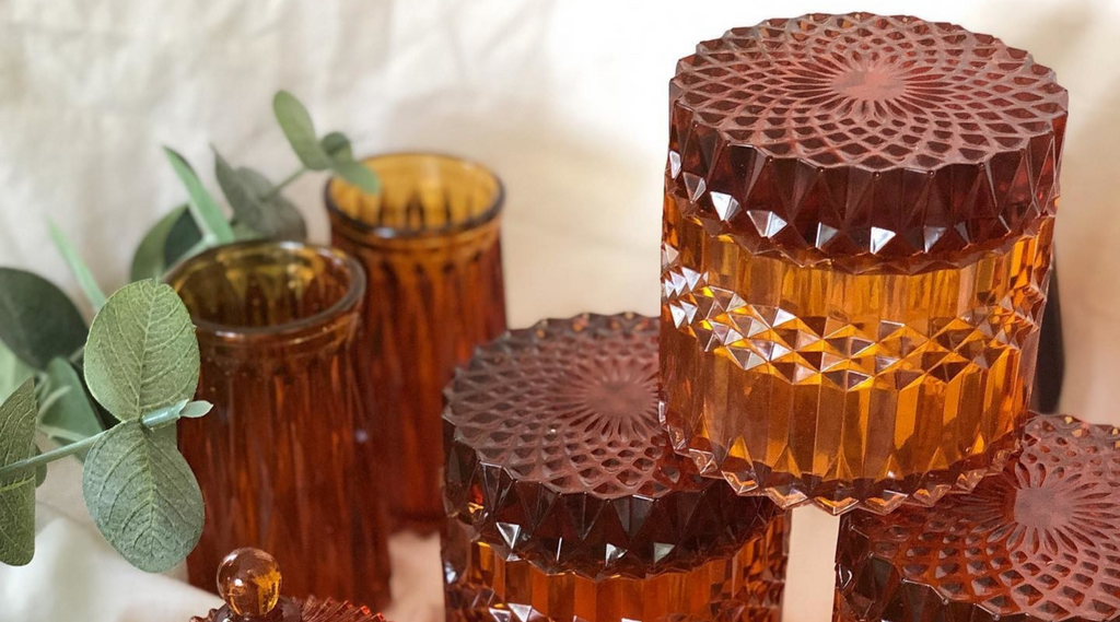 faux glass epoxy resin jars sitting on a silk background with amber alcohol ink for getting the colored epoxy