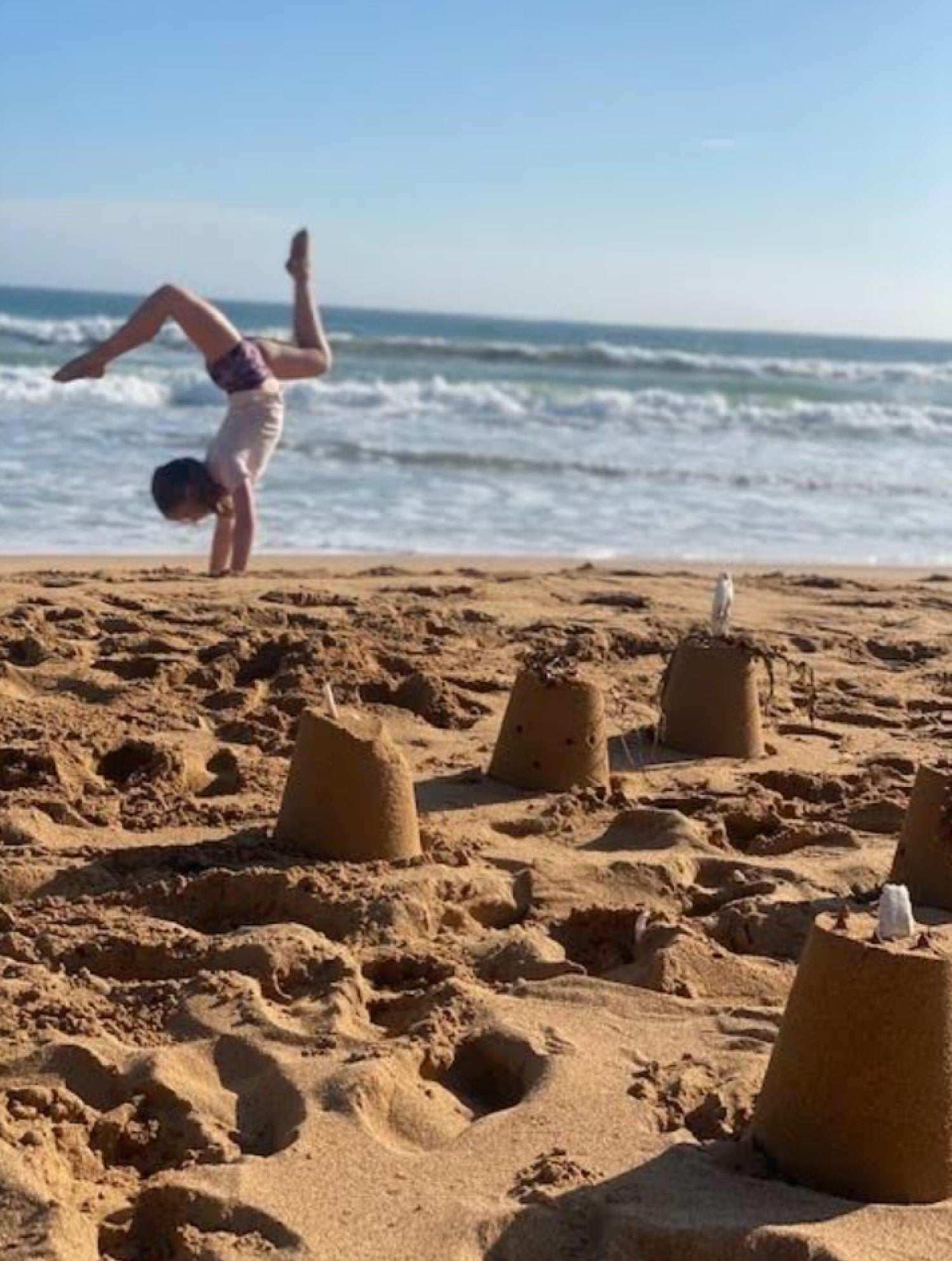 Narelle's daughter doing gymnastics on the beach