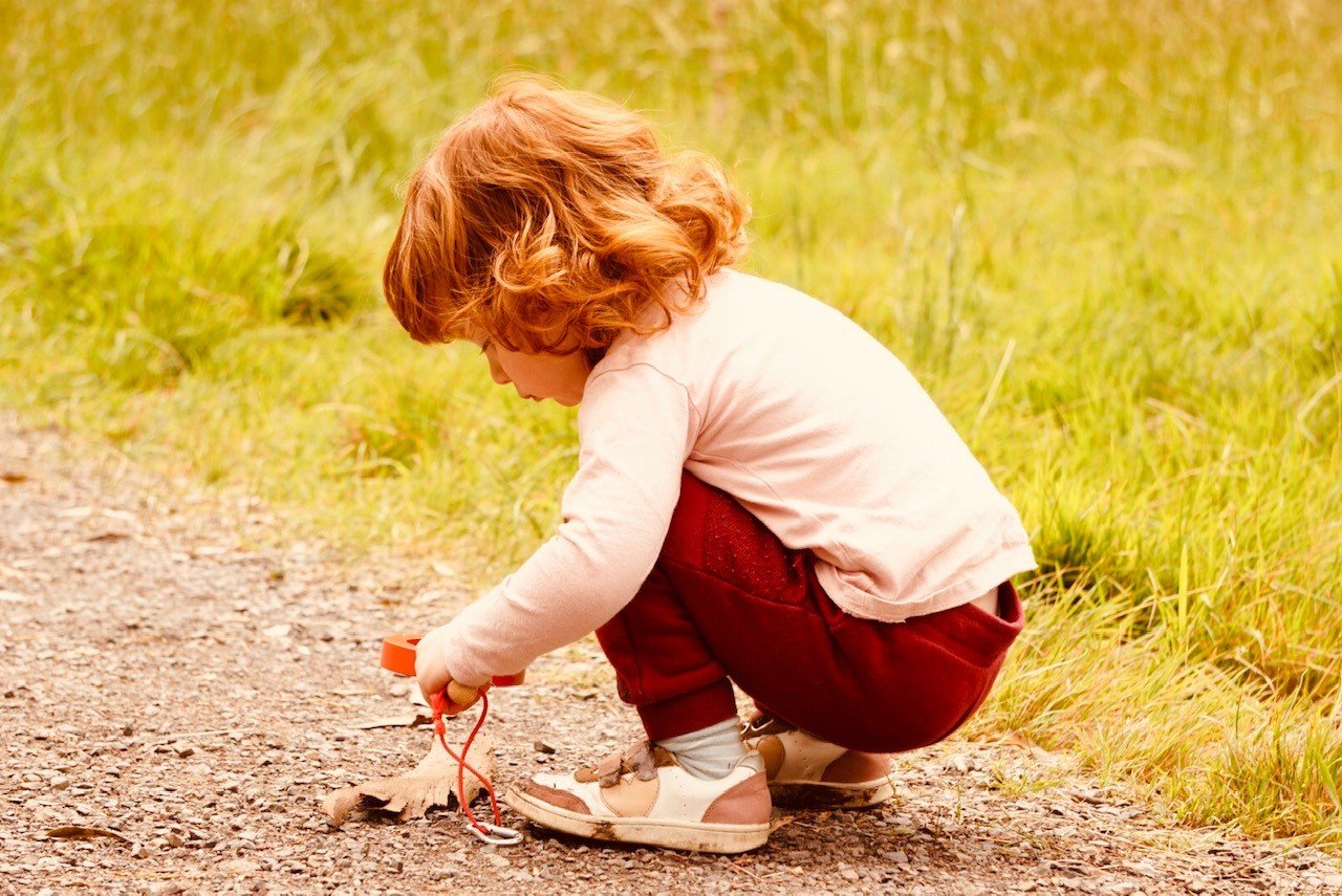 little girl looking through magnifying glass