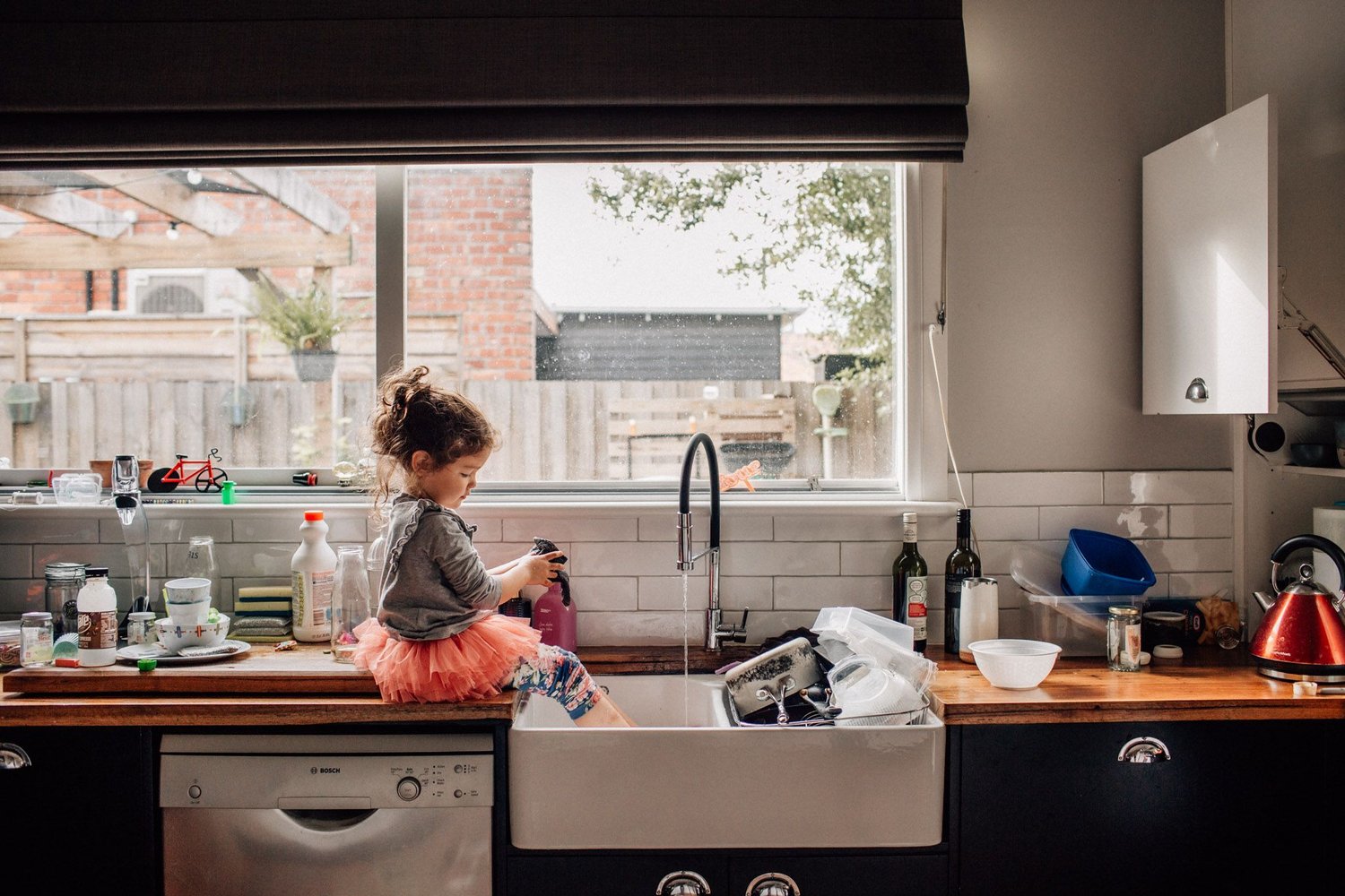 Girl sitting with legs in the sink