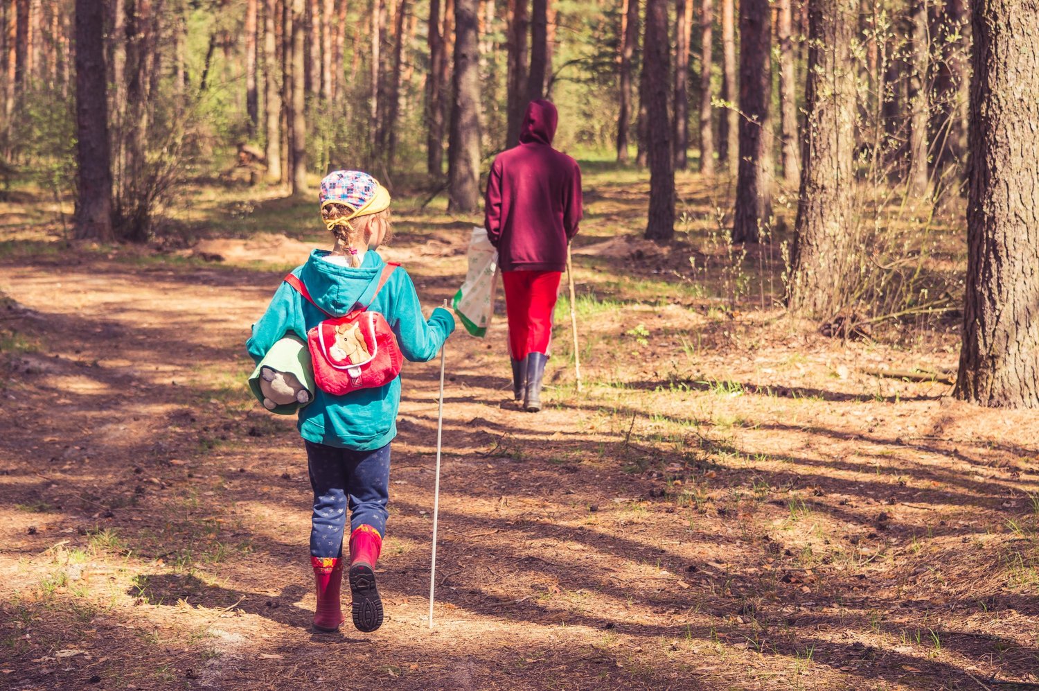 Girl with backpack walking into a forest