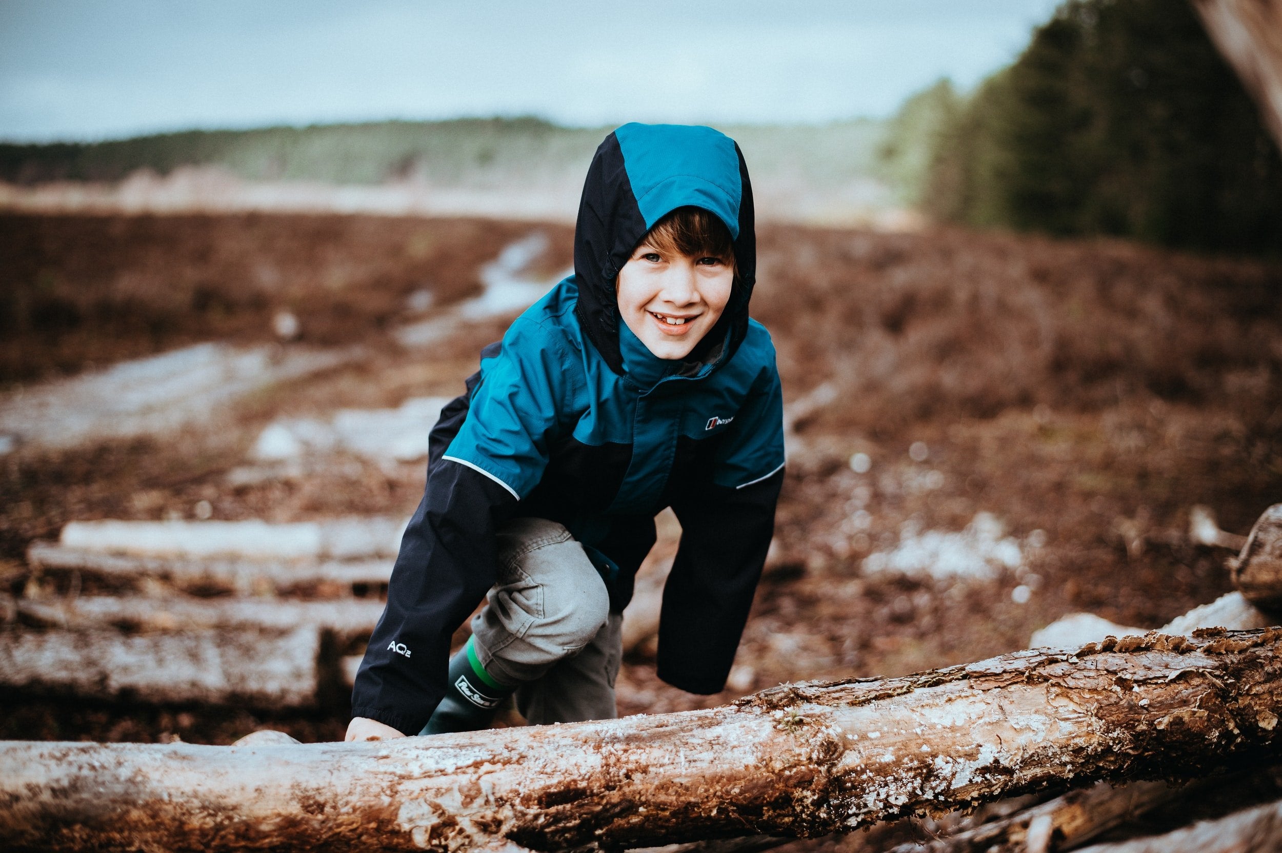 Child crawling towards a log