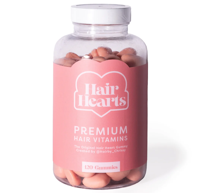 Bottle of Hair Hearts premium hair vitamin gummies with a pink label.