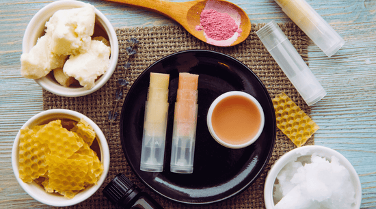  lip balm containers in a bowl  beside natural ingredient of shea butter beeswax and coconut oil