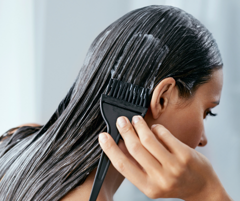 woman applying hair products  on her hair