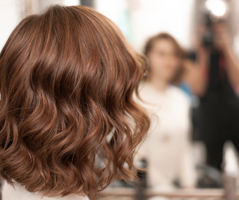 woman with short curly hair facing the mirror