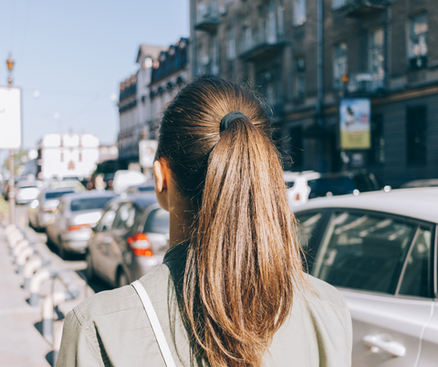 woman in her ponytail hairstyle walking in the street