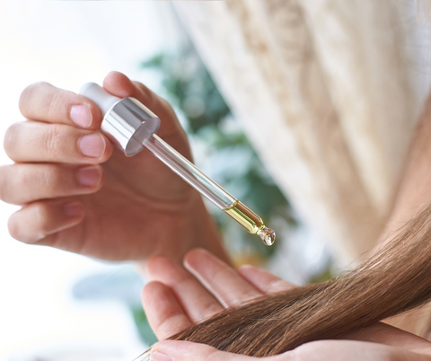 woman applying vitamin E on hair