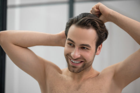 man smiling while combing hair