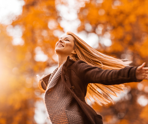 very happy woman in autumn trees