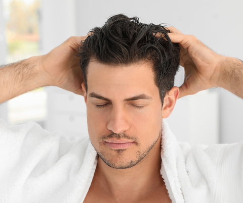 man applying hair gel on hair