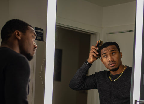 man brushing his hair in the mirror