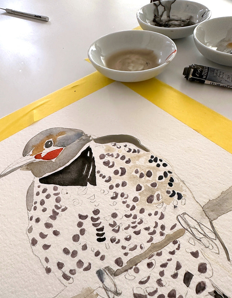 start of a watercolor painting of a woodpecker with paint tray in background