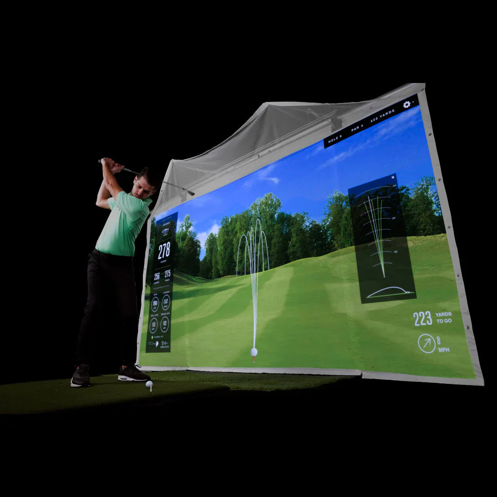 man swinging golf club in homecourse simulator