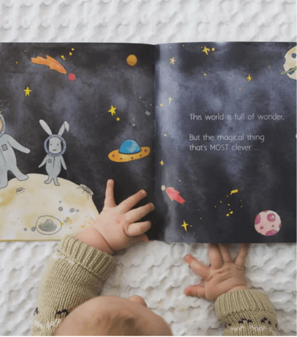 Baby-Looking-at-Images-in-In-A-World-Full-of-Magic-Book-Naked-Baby-Eco-Boutique