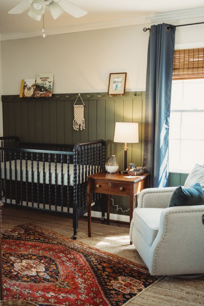 Green panel baby bedroom with accent rug