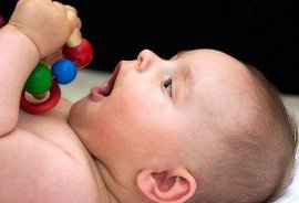 Baby playing with a wooden toy