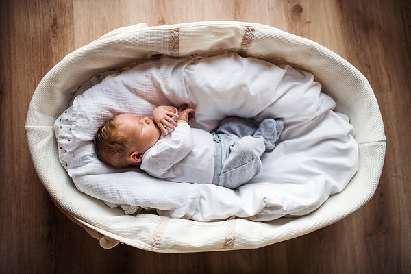 Newborn baby sleeping in moses basket