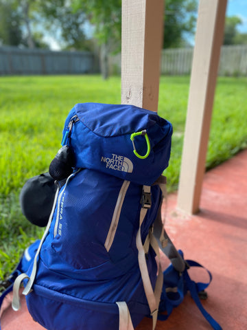 A blue backpack ready for the Camino de Santiago leaning against a pole