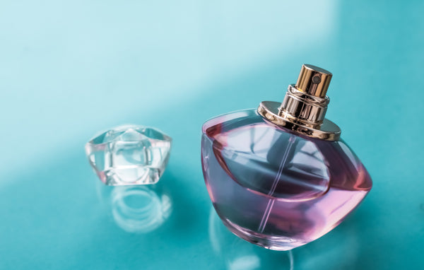 Un parfum avec le capuchon enlevé posé sur une table