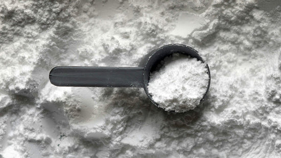 Nine Realms CBG Isolate powder with a grey plastic spoon
