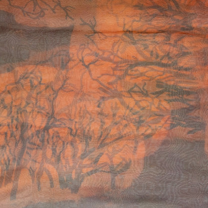 Close up of a Silk Scarf with a color mixture of dark brown tones with orange and a faint tree branch print blended into the colors