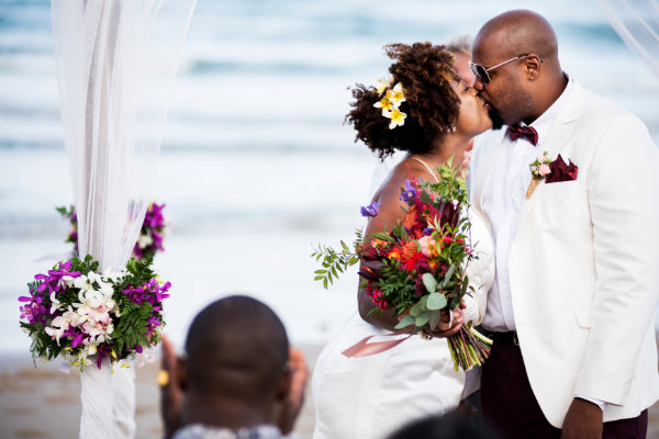 A bride and groom with a beautiful floral backdrop