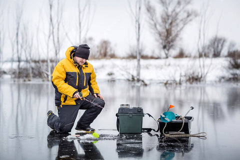 Man ice fishing on a frozen lake